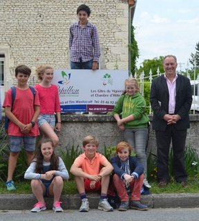 Pupils + sign outside house